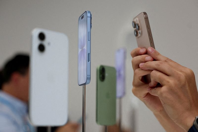 Evento da Apple em Cupertino  • Uma pessoa usa um telefone para fotografar iPhones em exposiç...